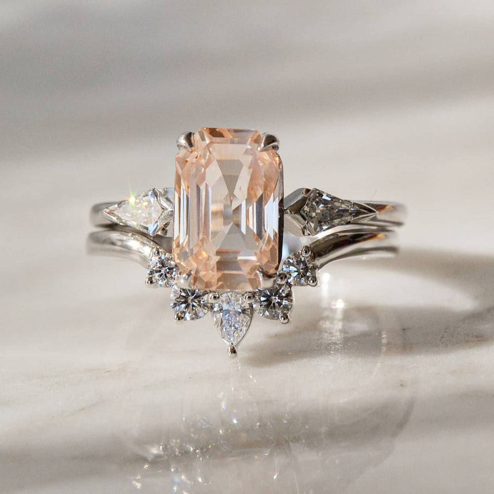 A close-up of emerald cut Rose Gold Diamond Engagement ring placed atop a shiny surface