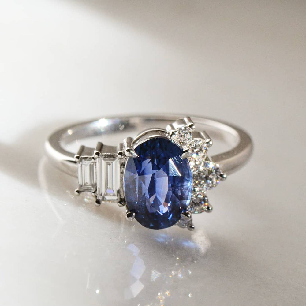 A close-up of Oval Cut Blue Sapphire Diamond placed on shiny surface