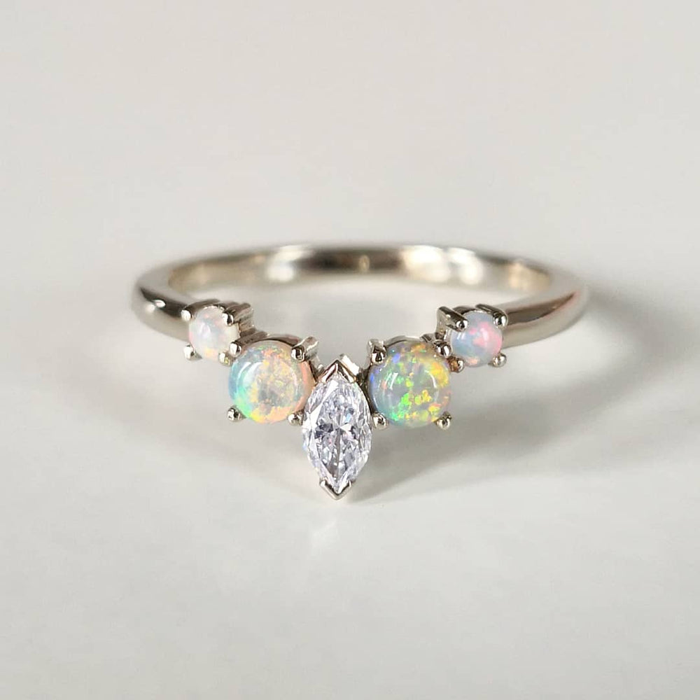 A Marquise and Circle Cut Opal five-stone Diamond Ring in white surface in a white background