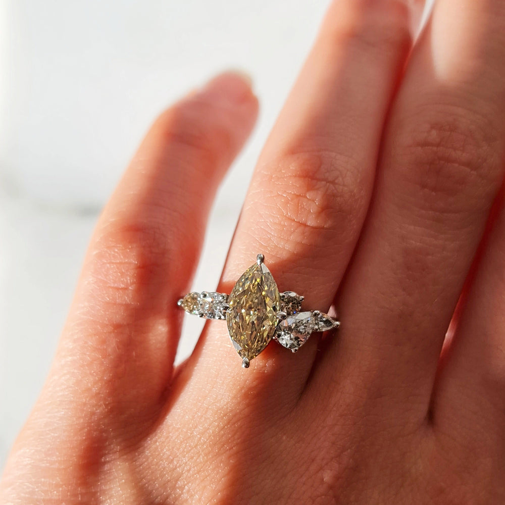 A close-up of a hand with a beautiful Marquise Cut Diamond ring in its ring finger
