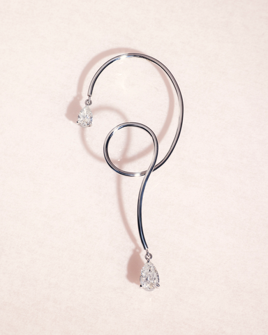18ct white gold earring cuff with pear cut diamonds on a light pink background