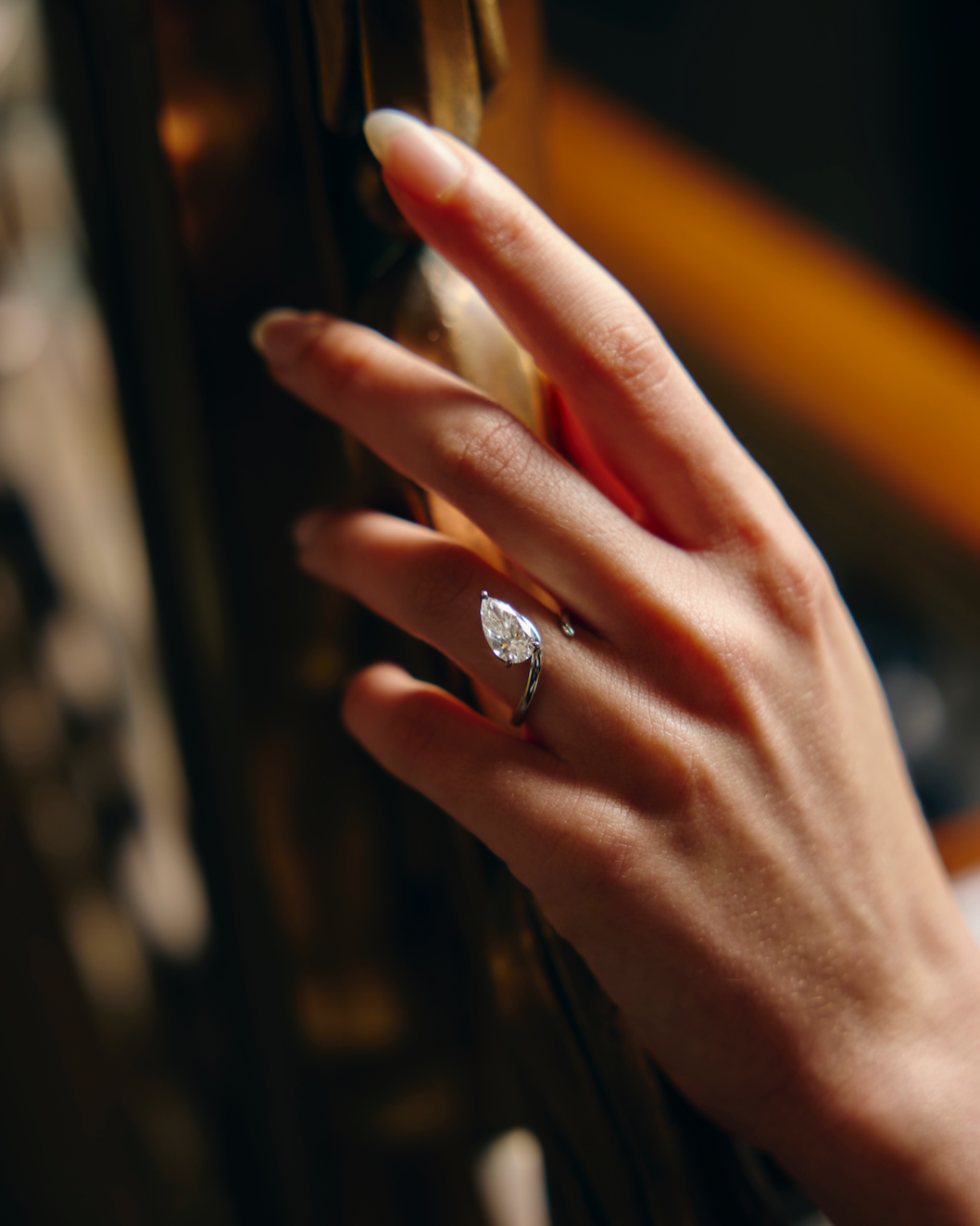 Hand with a diamond ring on a blurred background