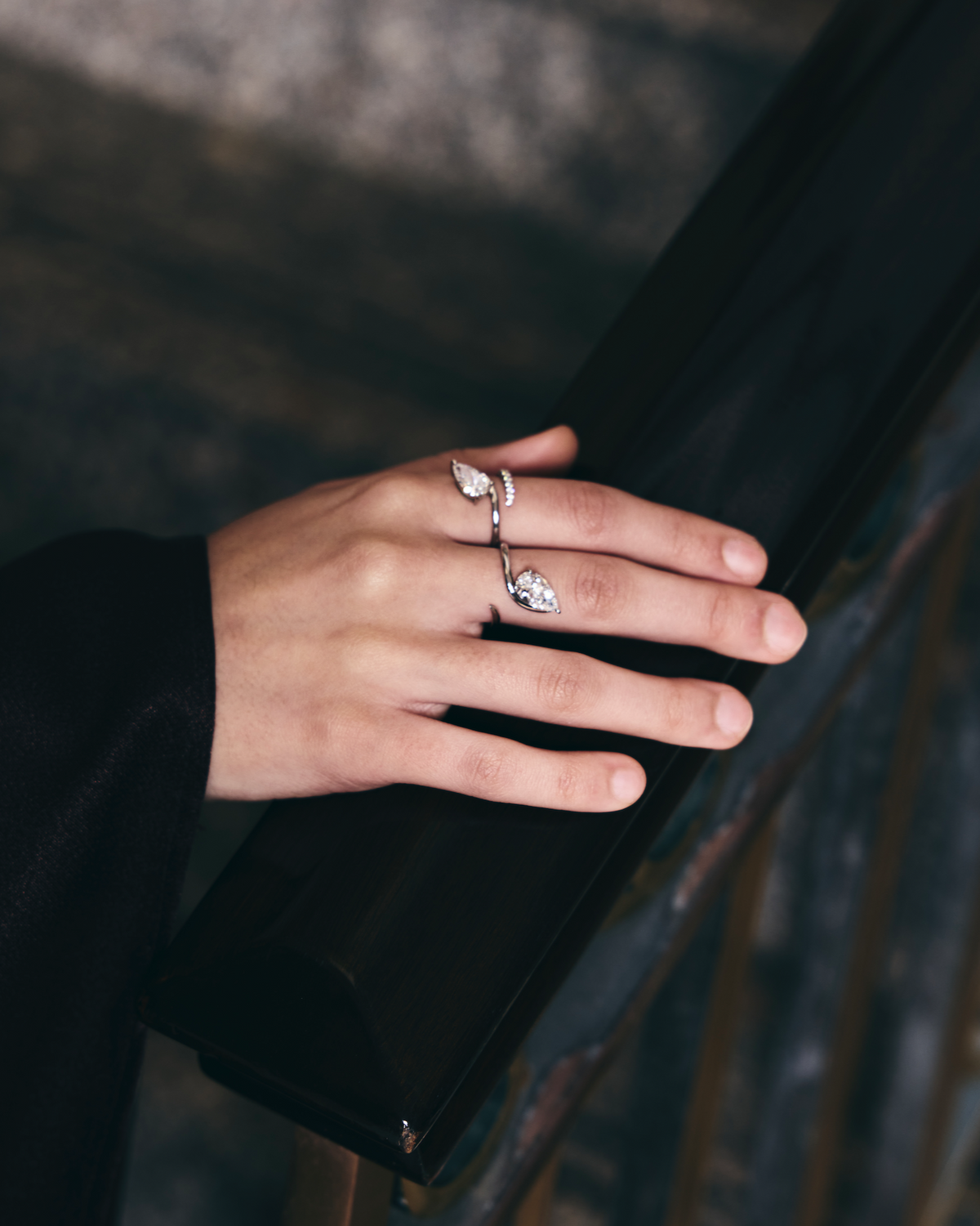 Hand with rings on a dark surface
