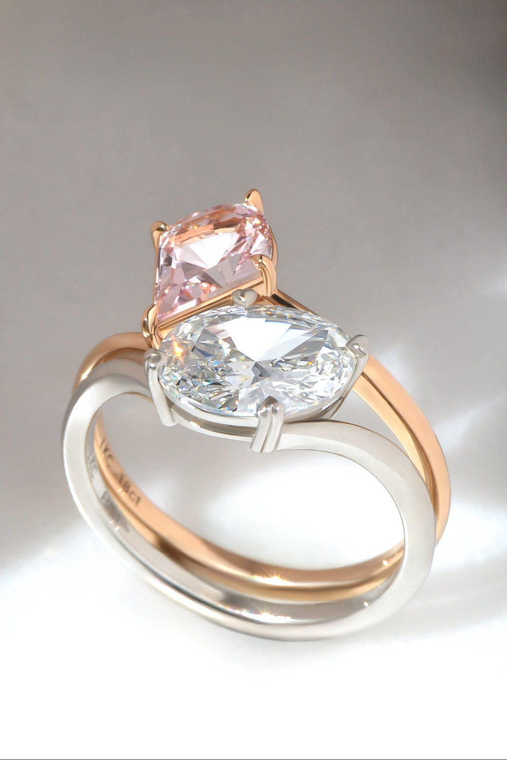 Two rings designed as toi-et-moi - The first ring, an Oval Cut White Diamond Set in a Curved Platinum Band. The second, a Modified Pear Cut Pink Sapphire, Set in 18ct Rose Gold.