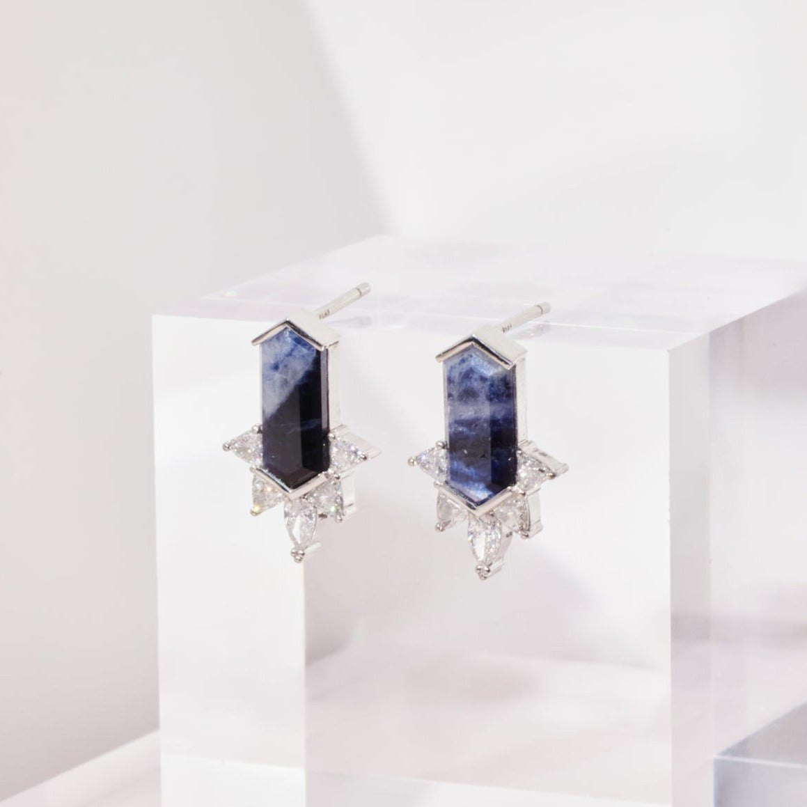 A stunning hexagonal cut Sapphire Diamond Earring placed on a white shinny surface