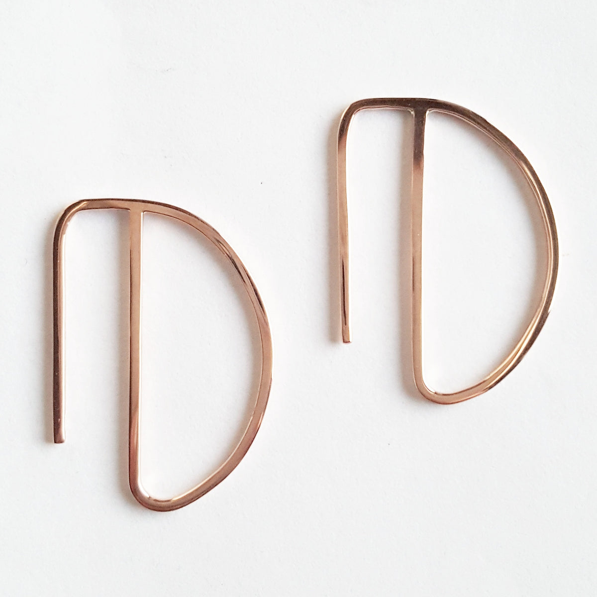 A stunning pair of Solid Gold Hoop Earrings with a unique design, placed on a white background.