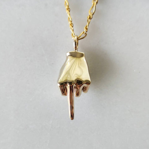A yellow 9ct Gold Pendant with a beautiful chain & middle finger design placed on a white surface