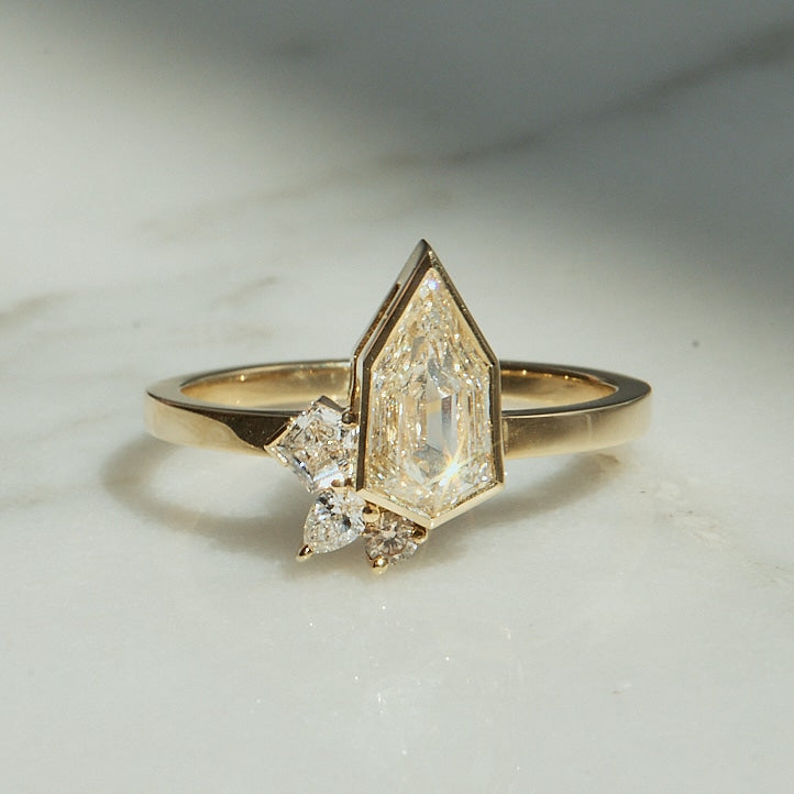 A Shield Cut Diamond Ring placed on a shiny surface.